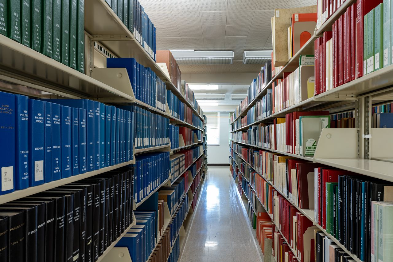 Wide aisle of bookshelves in an academic library at Washington State University.
